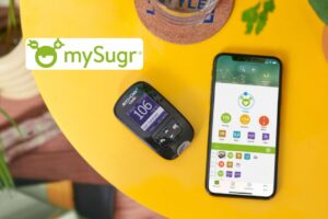 The MySugr app is open on a smartphone next to a glucose meter, illustrating the intelligent integration between the app and the physical device to facilitate daily diabetes management.